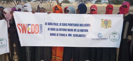 Jeunes filles avec la banderole « Je suis fille, je suis porteuse des rêves »